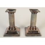A pair of low, filled silver, classical candlesticks.