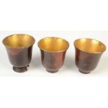 A set of three 19th century turned wood cups, each with gold plated copper lining, height 7cm.