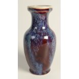 A Chinese flambe glazed baluster vase with slender waisted neck supporting a rimmed mouth,