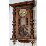 A German wall clock with a brass Junghans movement in ornate walnut case.