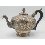 An 18th century ornate continental silver teapot with birds head spout and fir cone finial.