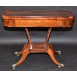 A Regency inlaid, foldtop card table on four sabre legs with lions paw feet, width 91.5cm.