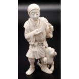 A Japanese ivory okimono, a standing peasant holding two fragmentary objects,