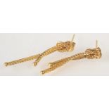 A pair of knotted gold tassel earrings.