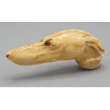 A 19th century ivory cane handle carved as a greyhound head, with paperweight glass eyes.