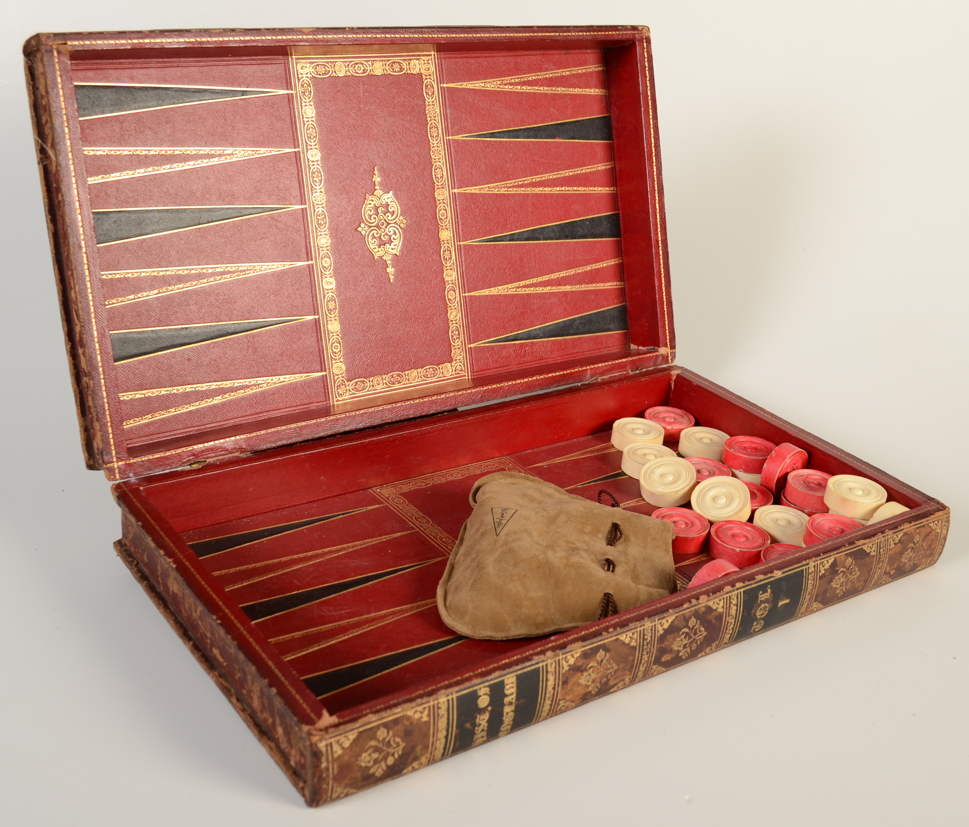 A set of red and natural bone draughts, in a good tooled gilt leather bound book case/board.