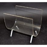 A 1960s curved lucite magazine rack standing on four white metal feet, height 26.4cm.