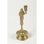 A 16th century style brass candlestick the nozzle held by a figure on short spiral stem with bell