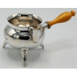 A Copenhagen silver brandy pan with three, horn shaped legs and a turned ivory handle.