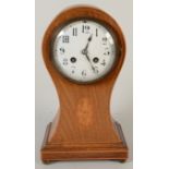 A late 19th century balloon mantel clock in an inlaid, waisted mahogany case,