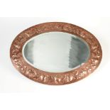 A good Newlyn Copper mirror, the oval frame with unusual decoration of chrysanthemum flowers,