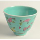 A Chinese porcelain beaker form tea bowl decorated in the famille rose palette with peony sprays on