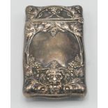 An American sterling silver vesta case with bacchanalian vines and masks.