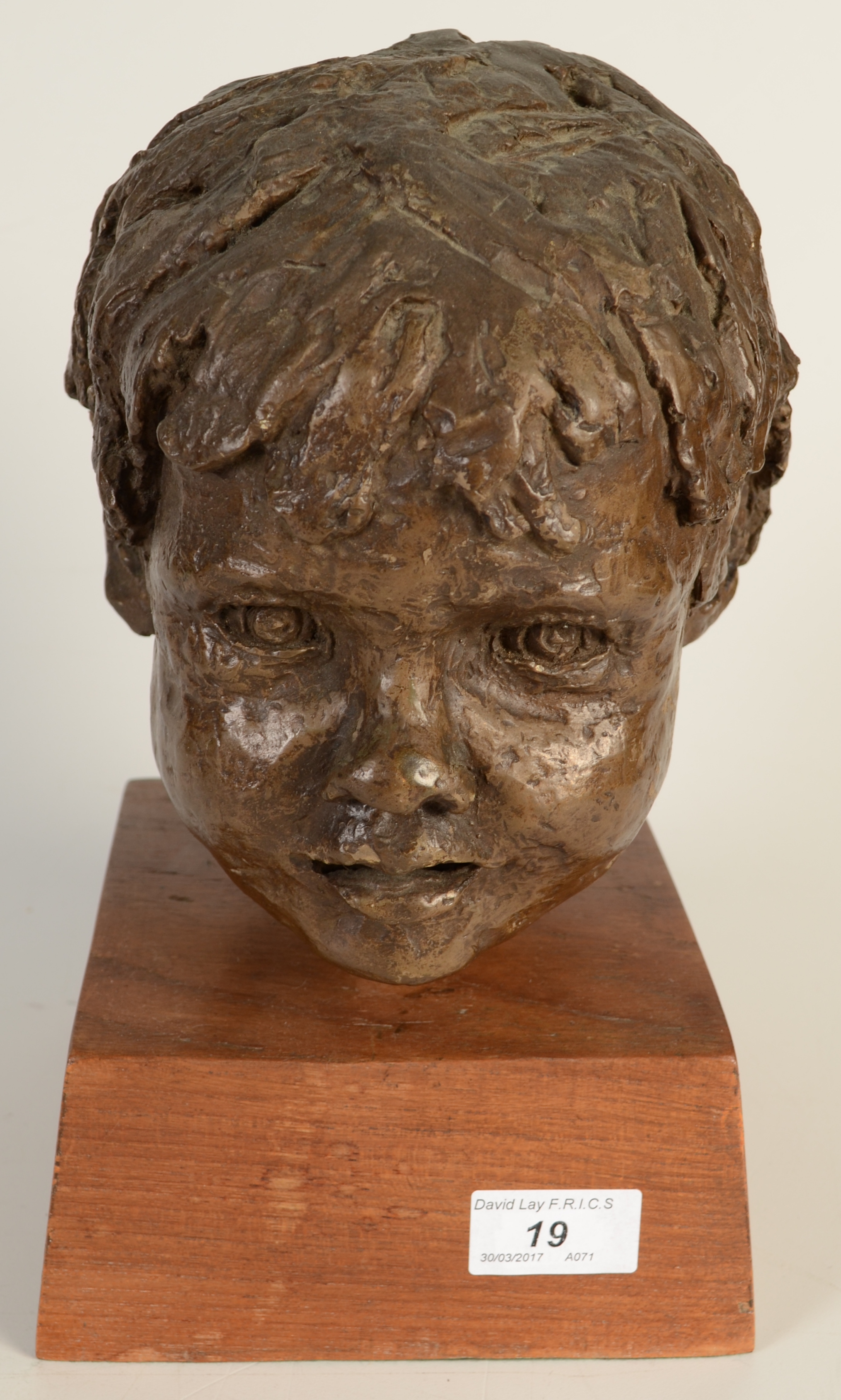 A resin sculpture, the head of a child on an oak base, monogrammed PMV (?), full height 28cm.