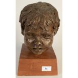 A resin sculpture, the head of a child on an oak base, monogrammed PMV (?), full height 28cm.