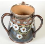 A late 19th century Doulton Lambeth stoneware tyg with silver rim hallmarked for London 1898,