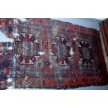 A Belouch rug with three octagonal medallions, all with guls, within a madder, starburst gul border,