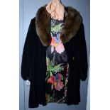 A lady's 1920s black velvet cape with a fox fur collar and floral printed black silk lining,