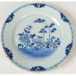 A Chinese 18th century blue and white plate decorated to the centre with a pavilion wall,