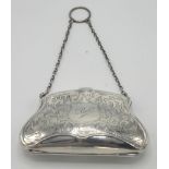 An engraved silver early George V purse on finger ring chains.