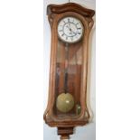 A continental Vienna regulator type wall clock with a single brass weight in a walnut case,