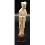 A Chinese ivory slender figure of a standing court official dressed in long flowing robes,