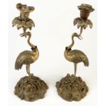 A pair of brass candlesticks cast with storks, possibly by Abbot,