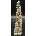 A Japanese walrus ivory group carved as a pyramid of figures shown as a seated figure of Daikoku