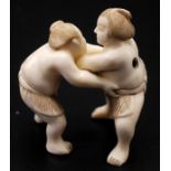 A Japanese ivory netsuke, two Sumo wrestlers standing facing each other,