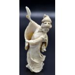 A Japanese ivory okimono, a standing Geisha in a dance pose and holding a partially open fan,