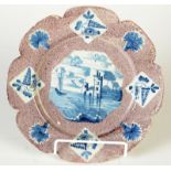 A rare 18th century English delft flower head shaped plate with manganese border decorated with a