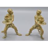A pair of brass Venetian style candlesticks cast as robed monkey attendants,