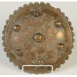 A Indonesian brass shield, (Buckler) circa 1900, with seven plain bosses, diameter 24.5cm.