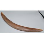 A boomerang carved with a kangaroo and emu in a landscape, length 63cm.