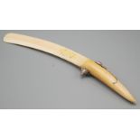An ivory paper knife the handle is pierced with the silver model of a mouse with red gem eyes.