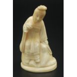 A Japanese walrus ivory figure of a goddess style lady seated upon a rock,