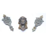 A pair of gilt metal satyr cast furniture mounts and one other similar mount cast as the head of