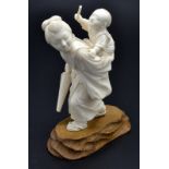A Japanese well carved ivory okimono of a mother out strolling,