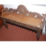 A carved light oak hall bench.