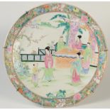 A large Japanese charger decorated to the centre with figures in a garden scene,