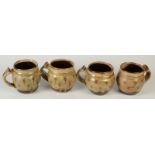 Four Michael Cardew, Winchcombe Pottery mugs, each decorated with sgrafitto leaves, height 10.5cm.