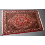 A Persian rug, the indigo field with a large polychrome medallion within multiple borders,