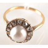 An antique gold ring with a pearl and diamond cluster.