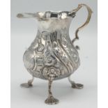A mid 18th century silver bellied milk jug by Samuel Meriton with floral embossed spiral fluted