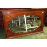 An Edwardian overmantle with oval glass, the mahogany frame with intricate inlay, width 136cm.