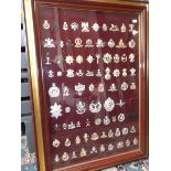 A collection of military cap badges, framed as one 25 x 34 ins.