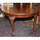 A mahogany extending dining table on carved cabriole legs with ball and claw carved feet,