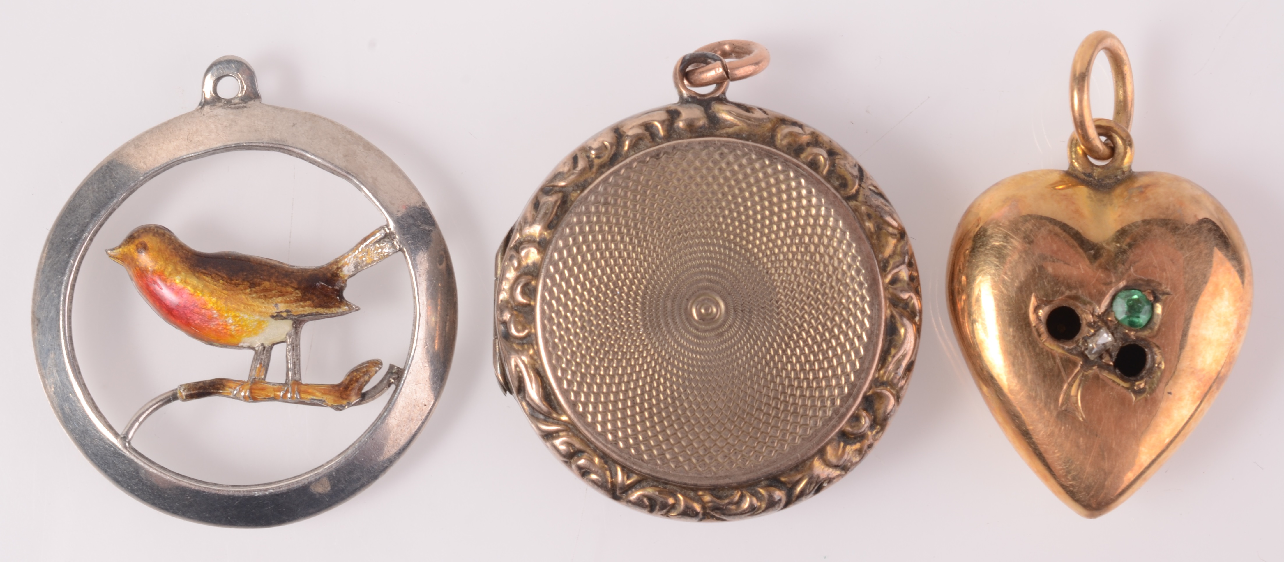 An enamelled silver pendant, a gilt locket and a 15ct gold heart pendant (lacks stones).