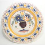 A Delft pottery polychrome plate, 18th century, decorated with a stylised vase of flowers,