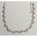 A silver wave and net link necklace marked DJ, London import marks.